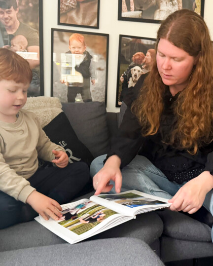 Lea Nybroe Mikkonen kigger sammen med sin søn i et fotoalbum med billeder af sin afdøde mand