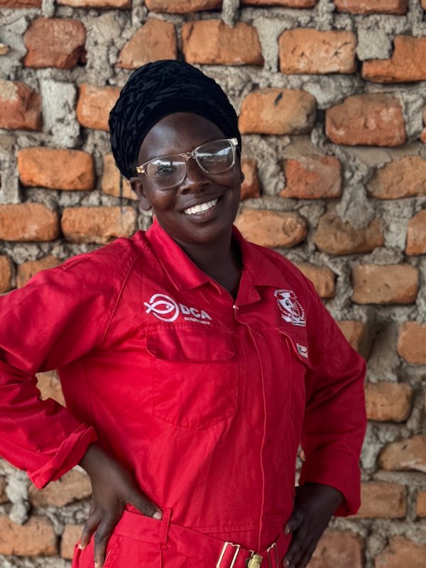 Ung afrikansk kvinde smiler i en rød kedeldragt