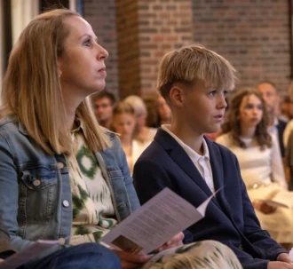 En konfirmand på sin særlige plads ved midtergangen i kirken under konfirmationen.