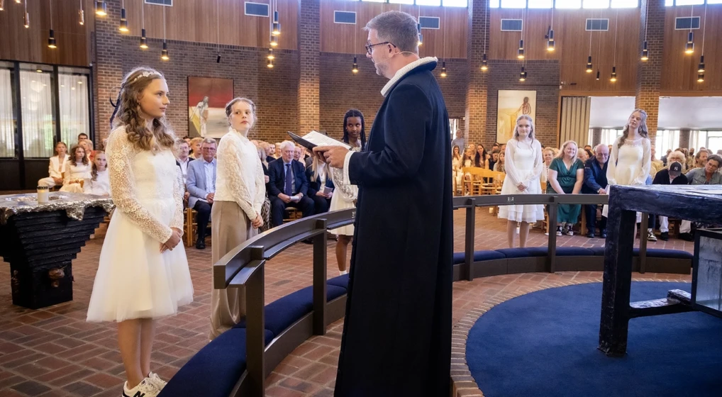 Konfirmand og præst. Ved konfirmationen får hver konfirmand sit eget konfirmationsord. Se de mest populære her.
