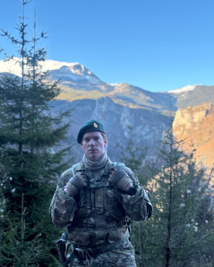 Adam garfr i uniform i bjerglandskab