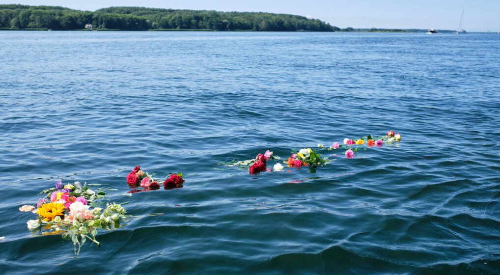 Askespredning Blomsterbuketter flyder i havoverfladen efter askespredning.