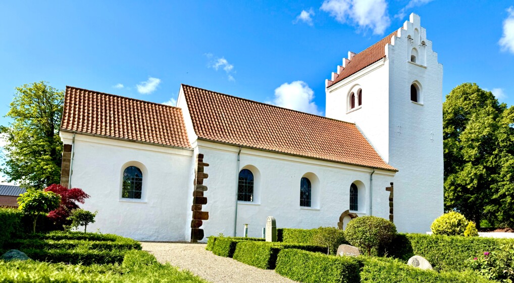 Vejlby Kirke3.jpeg Hvid middelalderkirke i solskin